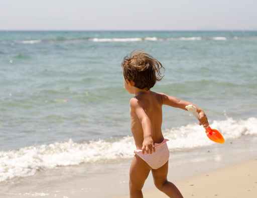 Happy kid playing with scoop standing near the ocean © jovannig - Fotolia.com
