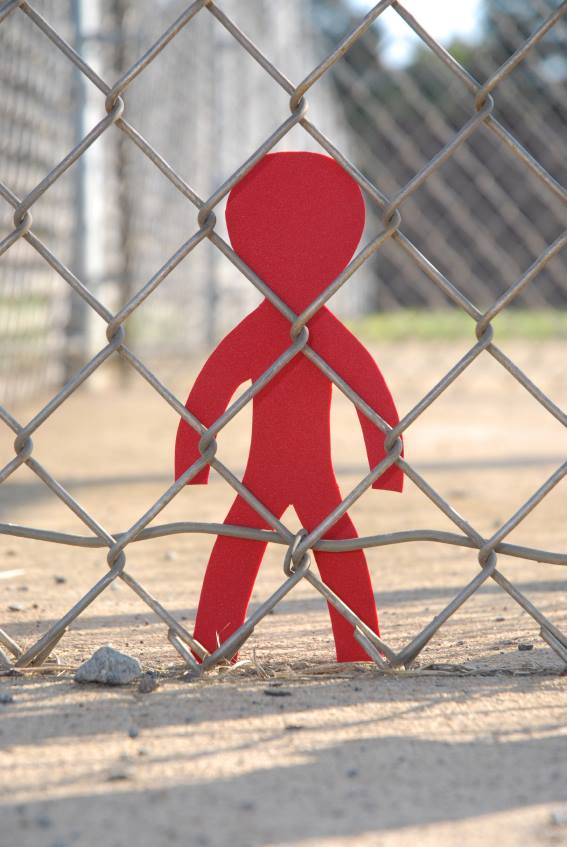 cutout figure behind barbed wire